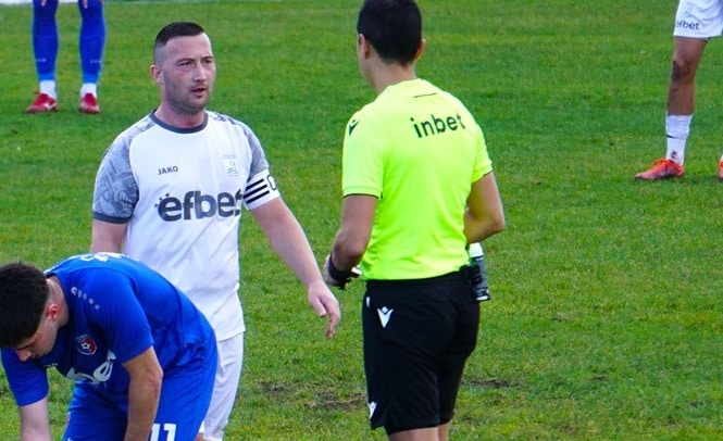 Робертин Атанасов вкара 11 гола през есента, Германея на дъното Капитанът и един от лидерите на Германея — Робертин Атанасов — реализира 11 попадения през есенния дял от сезона в Югозападната Трета лига. Това е почти половината от общия актив на отбора, който има 24 отбелязани гола. Въпреки временното последно място в класирането на Германея, Атанасов се задържа в Топ 5 на голмайсторската листа в региона. Пълната подредба в горната част на класацията по голове изглежда така: Борислав Балджийски (Ботев Ихтиман) — 21 гола Александър Аспарухов (Струмска слава) — 16 гола Георги Божилов (Рилски спортист) — 15 гола Деян Христов (Витоша Бистрица) — 12 гола Робертин Атанасов (Германея) — 11 гола (дели 5-ото място с Даниел Младенов) Даниел Младенов (ФК Кюстендил) — 11 гола (дели 5-ото място)