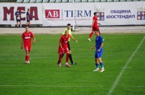 Струмска слава приема ФК Кюстендил в дерби от 26‑ия кръг Струмска слава ще бъде домакин на ФК Кюстендил в дербито между втория и третия в временната класация на Югозападната Трета лига. Двубоят е част от 26‑ия кръг и е насрочен за събота, 28 март, от 15:00 ч. на стадион „Христо Радованов“ в Радомир. В последния си мач домакините допуснаха грешна стъпка — 2:2 при гостуването на втория отбор на Септември, а преди това записаха загуба на собствен терен от ОФК Костинброд. Поради тези резултати Струмска слава вече са два мача без победа и изостанаха на 6 точки от временния лидер Рилски спортист. Старши треньорът Стефан Гошев няма да може да разчита на наказания Милен Войнов за предстоящия двубой. През есента Струмска слава загуби тежко с 0:3 в Кюстендил и сега тимът има амбицията да си вземе реванш.